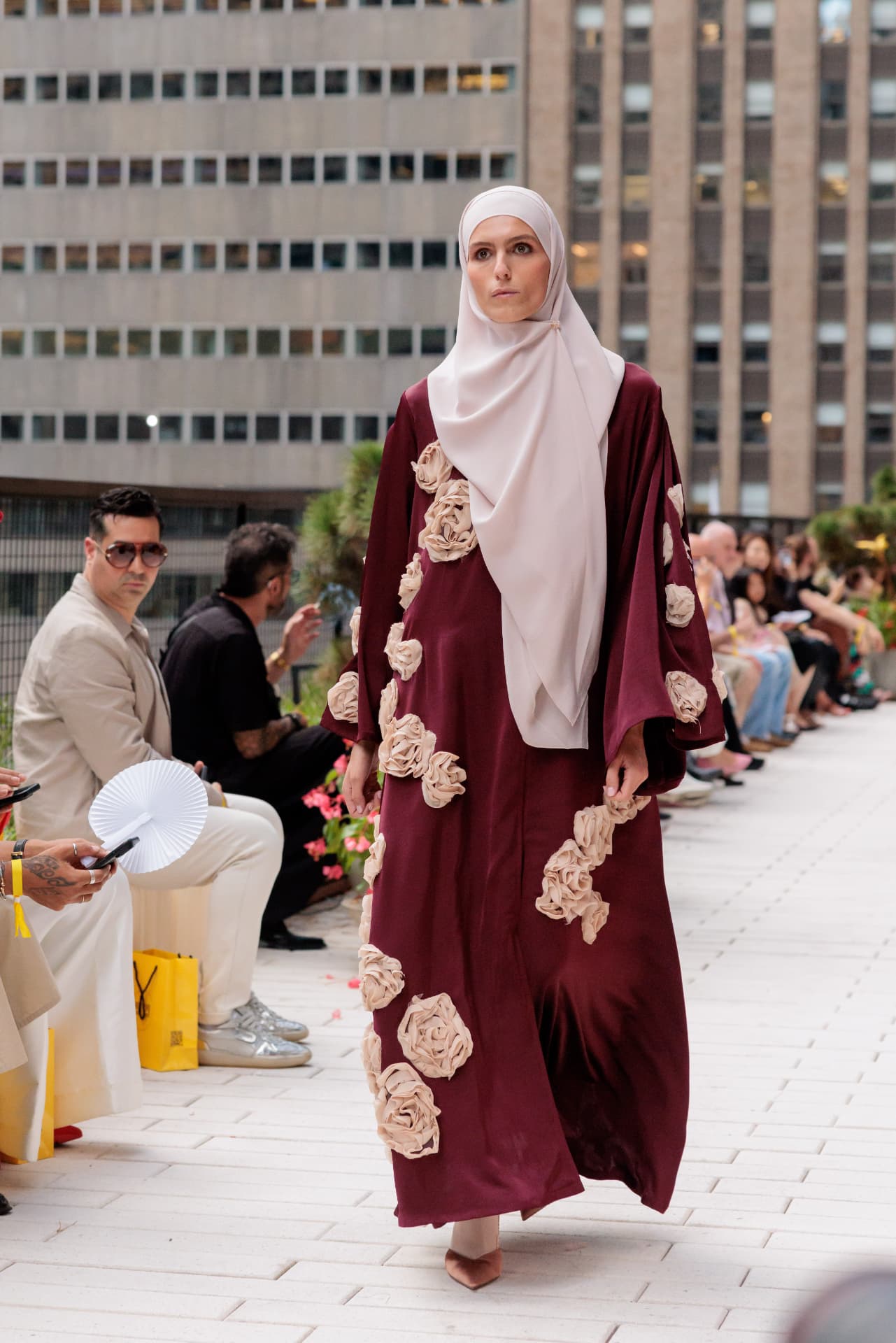 Model wearing a burgundy Zafira Abaya with sculptural floral details at New York Fashion Week 2026
